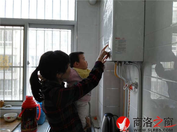 家住市區(qū)香菊小區(qū)的李女士正在操作自家剛剛安裝的燃?xì)獗趻鞝t，提升室內(nèi)的溫度。