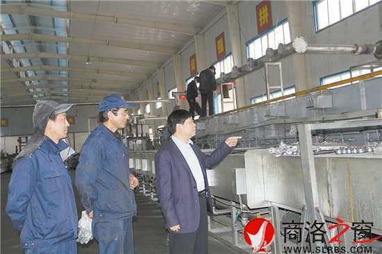 沈傳奇與技術(shù)人員正在研究7號爐窯技改問題