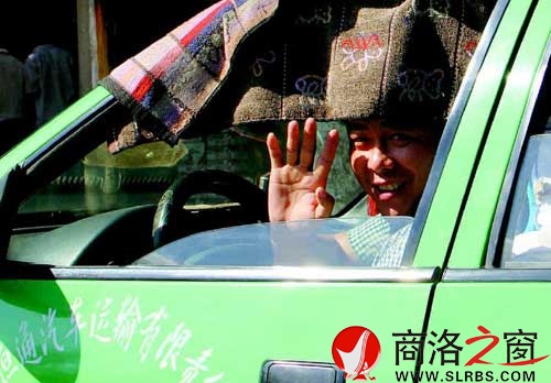 看到記者采訪，旁邊的出租車司機熱心地打了個招呼。