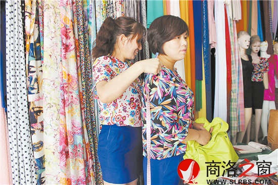 雷小莉仔細地為客人量尺寸，量體裁衣是裁縫鋪最大的優(yōu)勢。